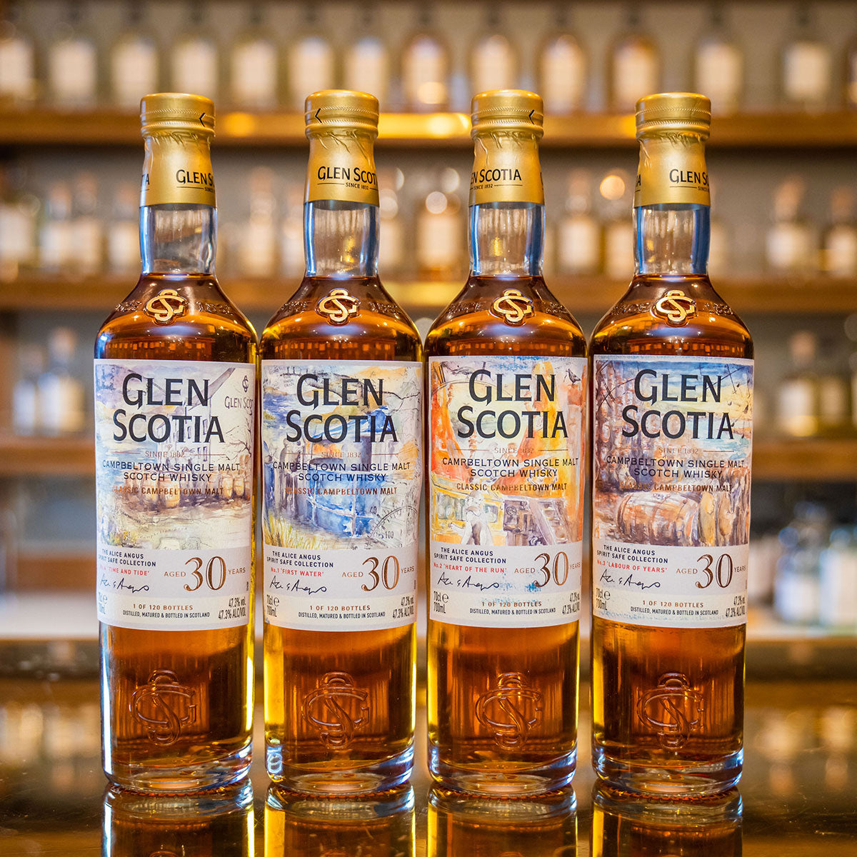 Four bottles of Glen Scotia 30-year-old Campbeltown single malt Scotch whisky are displayed on a reflective surface, with blurred shelves of bottles in the background. Each bottle features a detailed label with a maritime theme and a golden cap.