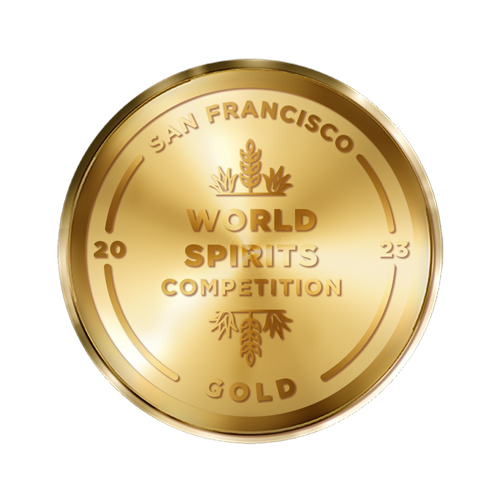 A gold medal with the inscription "San Francisco World Spirits Competition 2023 Gold." The design includes laurel and pine motifs, along with curved lines encircling the text.