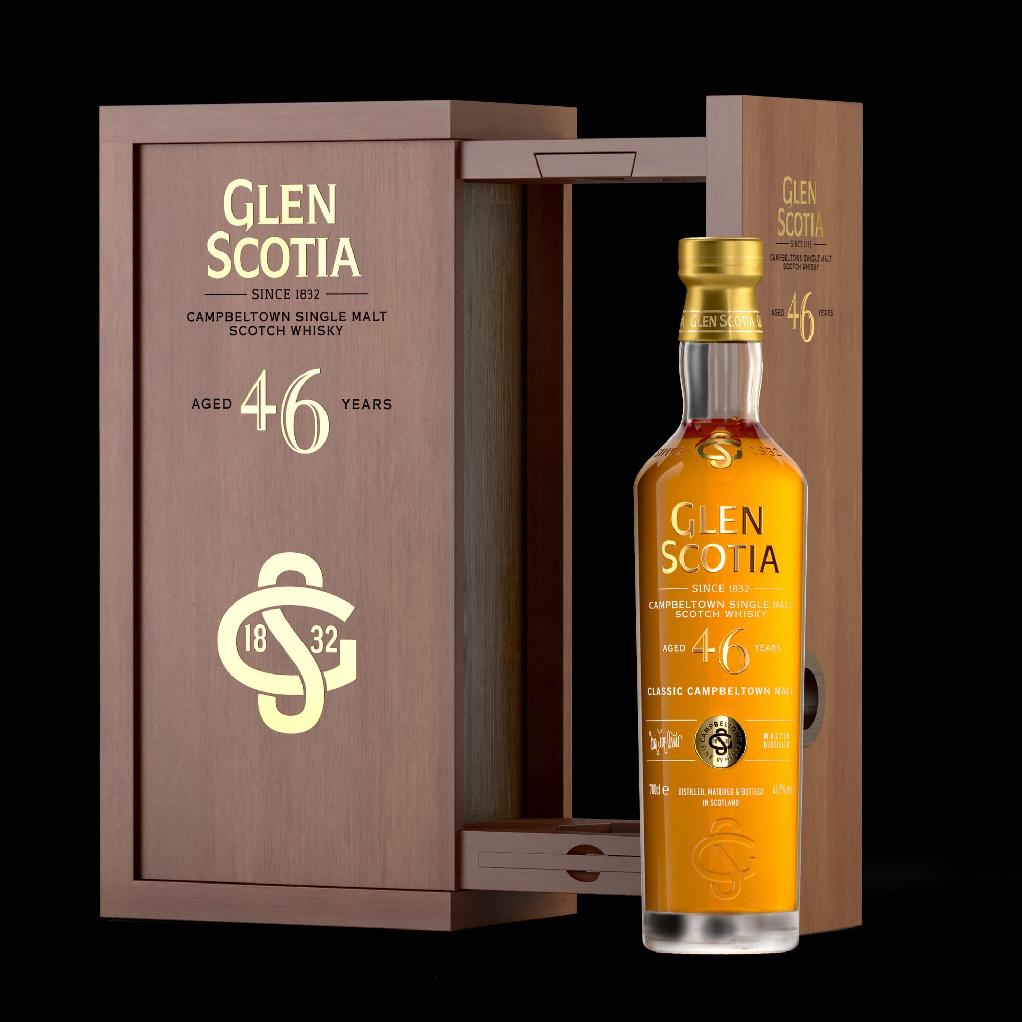 A bottle of Glen Scotia 46 Year Old Whisky is displayed with its wooden box open behind it. The bottle, adorned with a gold cap and a detailed label, boasts rich flavors from its first fill bourbon cask, while the box features gold accents detailing the whisky's age and origin.