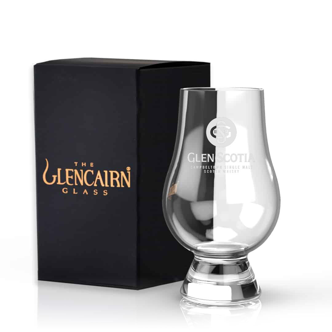 A clear, tulip-shaped Glencairn Glass with Glen Scotia Logo is displayed beside its black box packaging. The glass features the Glencairn logo alongside the "Glen Scotia" emblem, emphasizing its design tailored for enhancing scotch tasting experiences. Perfect for whisky gifts by Glen Scotia.