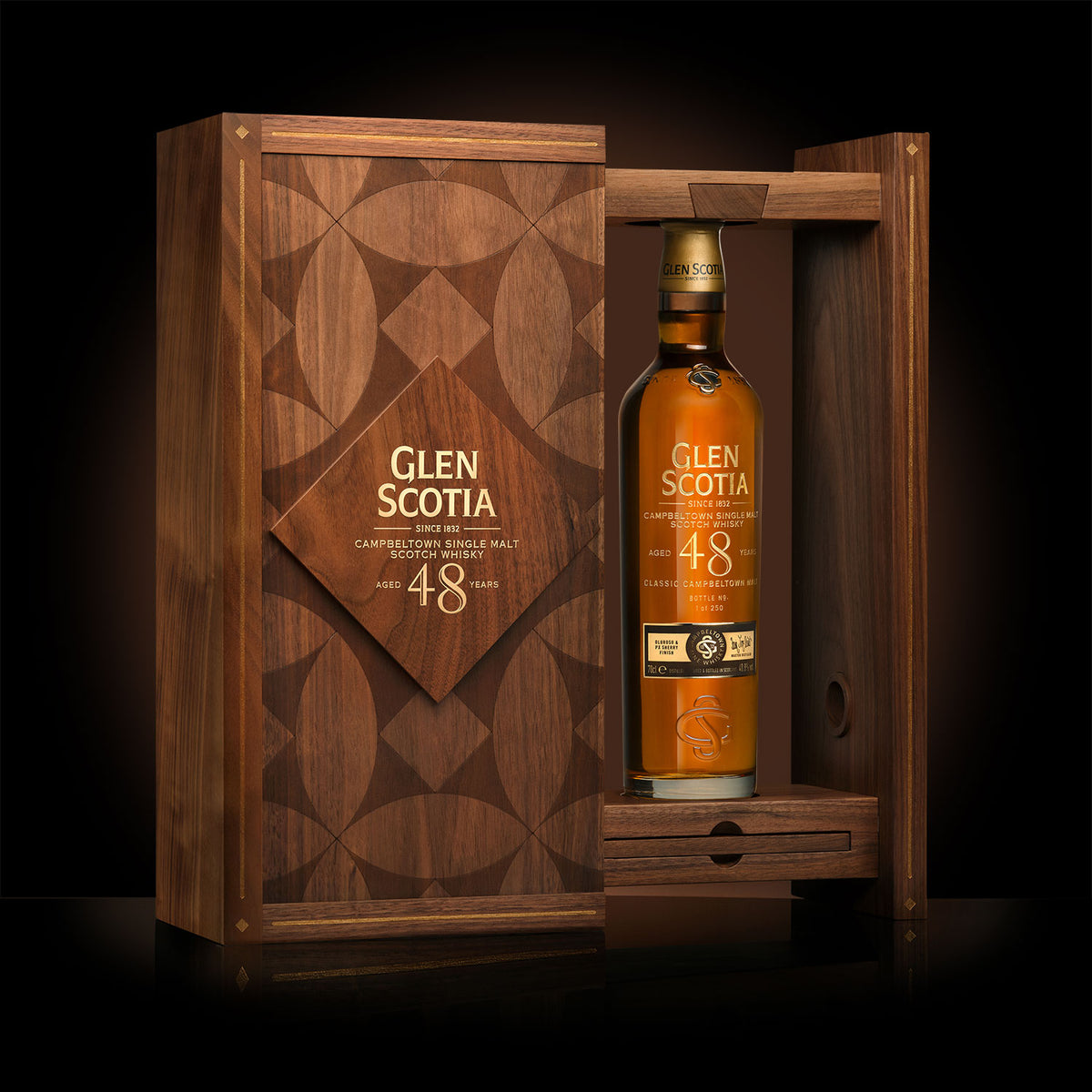 A bottle of Glen Scotia Old &amp; Rare 48 Year Old Whisky is displayed in an elegant wooden case adorned with intricate geometric designs. The open case reveals the gold-hued bottle standing upright against a black background.
