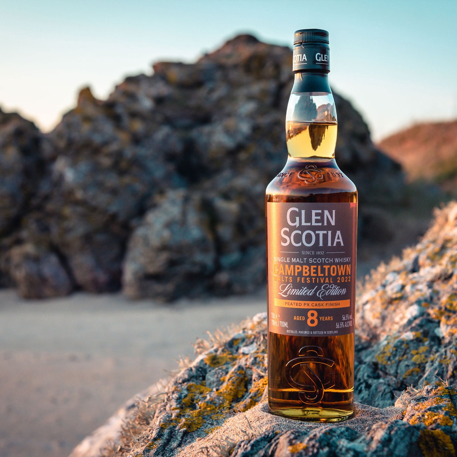 A bottle of Glen Scotia Campbeltown Malts Festival Edition 2022 stands next to its brown and gold box. The label on the bottle highlights its limited edition release for the Campbeltown Malts Festival 2022. The bottle is partly transparent, showcasing the golden amber whisky inside—a perfect whisky gift for enthusiasts.